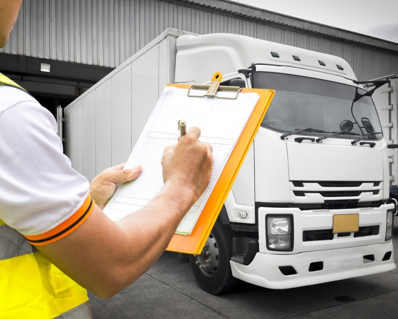 warehouse-worker-hand-holding-clipboard-inspecting-load-the-shipment-control-with-trucks-freight-industry-logistics-transport